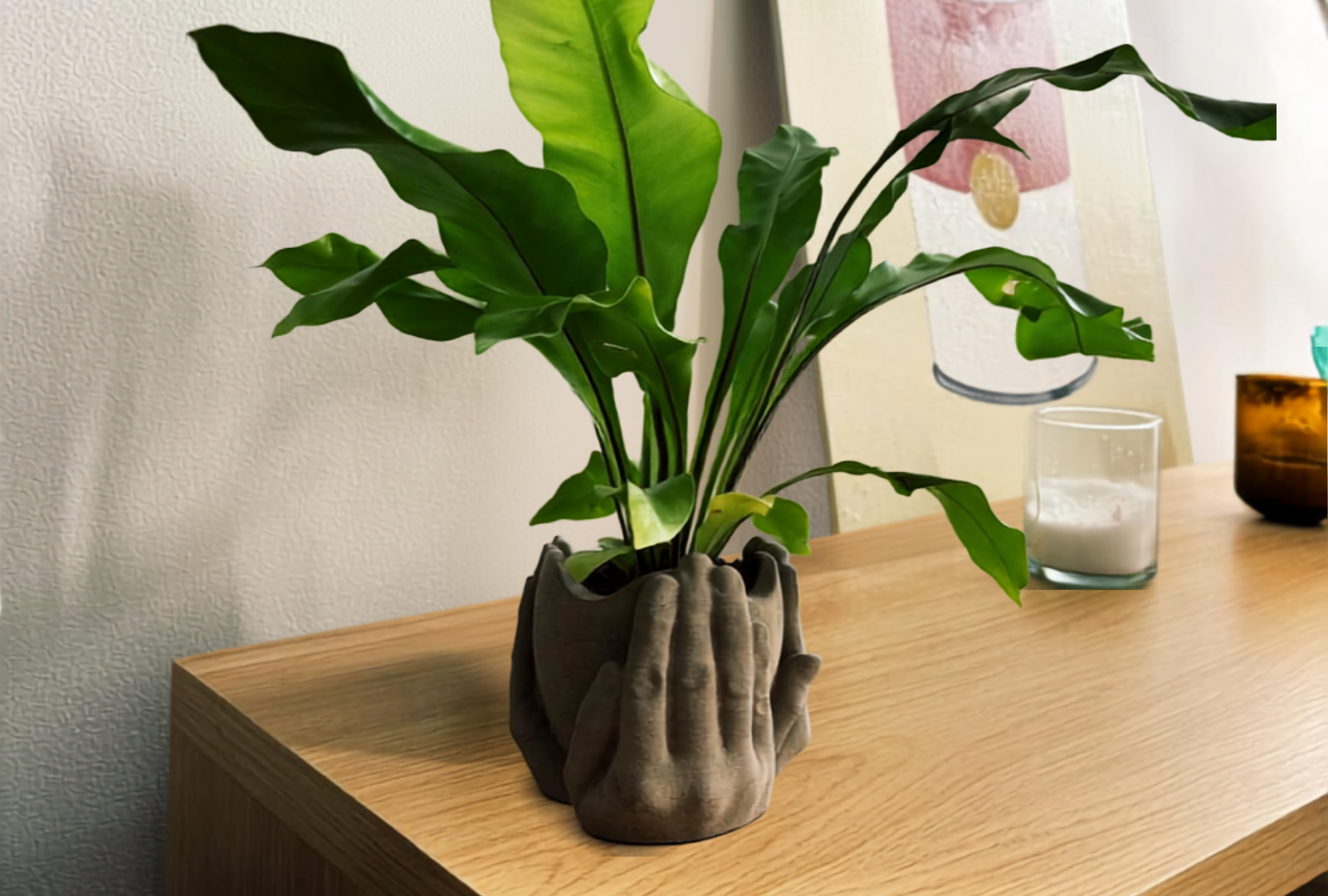 Render de la maceta con forma de manos, con una planta, en un ambiente doméstico
